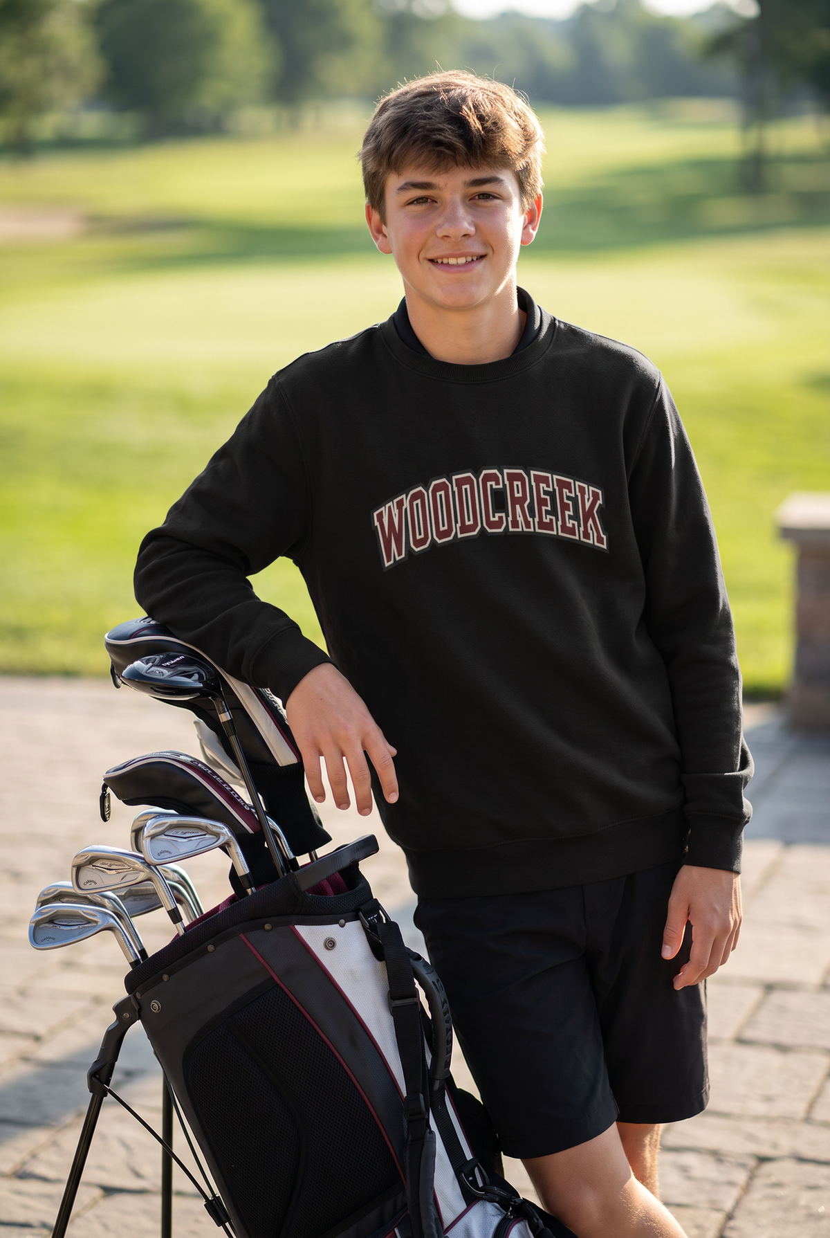Woodcreek Boys Golf College Letter Fleece Crewneck in Black with arched Woodcreek lettering, worn at the clubhouse
