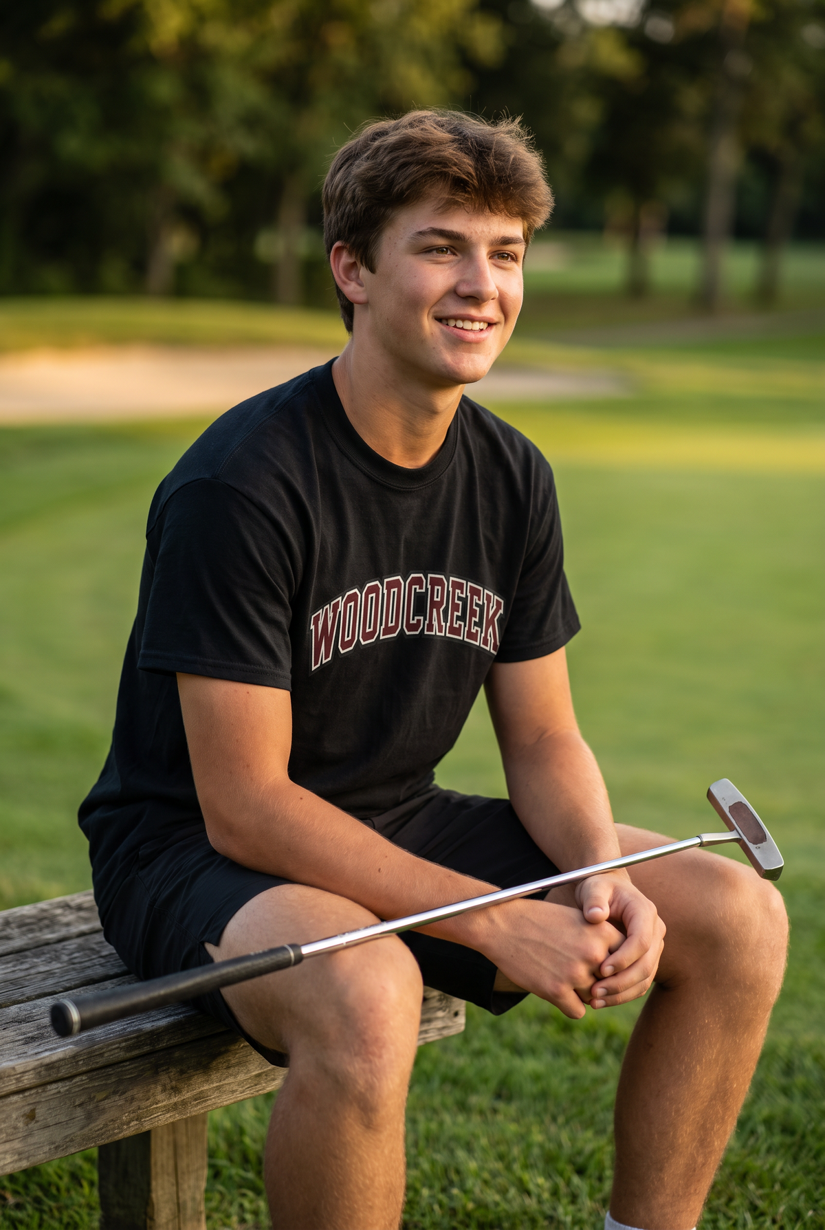Woodcreek Boys Golf College Letter Value Tee in Black, second view on the bench at golden hour