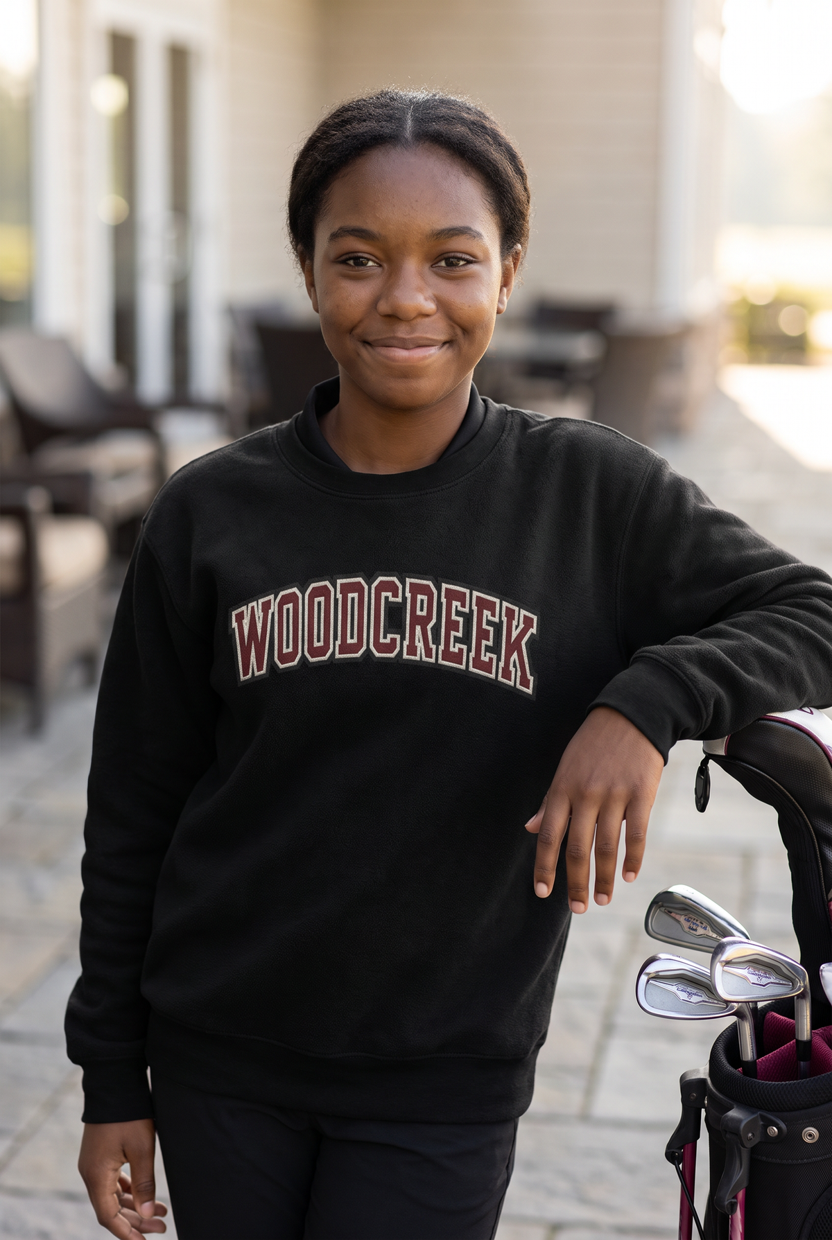 Woodcreek Girls Golf College Letter Fleece Crewneck in Black with arched Woodcreek lettering, worn at the clubhouse