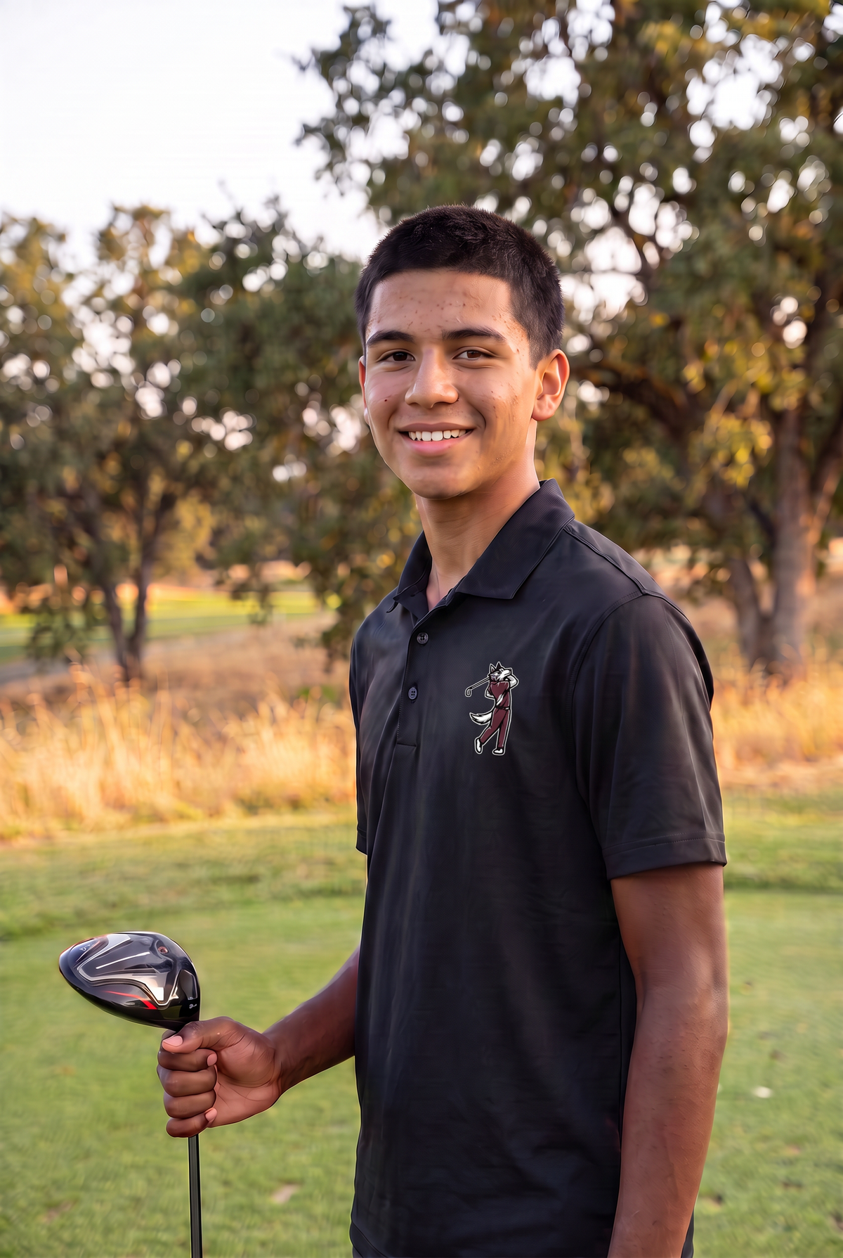 Woodcreek Boys Golf Swing Wolf Polo in Black, left-chest Swing Wolf, on the fairway