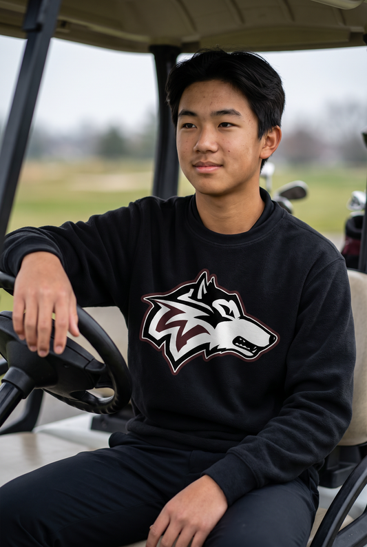 Woodcreek Boys Golf Fleece Crewneck in Black with the Woodcreek wolf head across the chest, worn in a golf cart