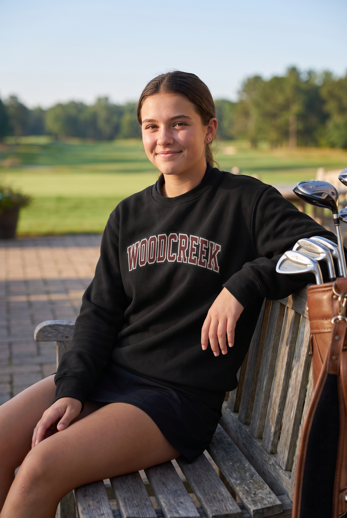 Woodcreek Girls Golf College Letter Fleece Crewneck in Black, second view on the clubhouse patio